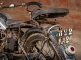 a old motorcycle parked in front of a brick wall