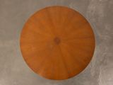 a round table with a wooden top on a concrete floor