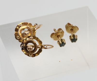 une photo d'un ensemble composé d'une bague et d'une boucle d'oreille en or, exposé en vitrine