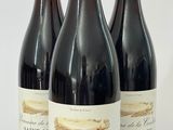trois bouteilles de vin sont alignées sur une surface blanche