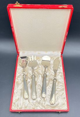 three silverware pieces in a red case on a table