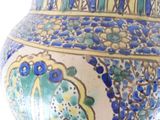 a blue and yellow vase sitting on a white surface