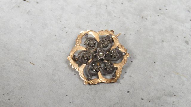 Broche en or 750‰, et argent, sertie de pierres blanches, travail...