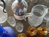 bottles and glasses on a table with a blue pitcher on it