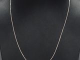 a white gold chain necklace on a mannequin neck