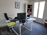 un bureau avec un ordinateur et une chaise dans une pièce