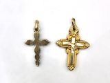 two gold crosses and a cross pendant on a white background