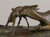 a bronze sculpture of two animals on a rock