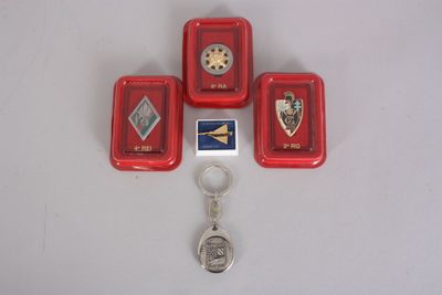 four red trays with badges and a keychain on a white surface