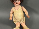 une image représentant une poupée assise par terre, vêtue d'une robe jaune