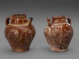 deux vases marron ornés de motifs, placés côte à côte