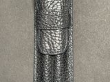a close up of a black leather case on a gray surface