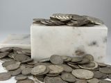 un bloc de marbre sur lequel se trouve une poignée de pièces de monnaie
