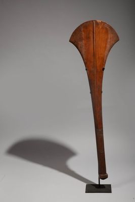 an image of a wooden sculpture on a stand with a shadow