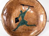 a brown bowl with a green silhouette of a man holding a baseball bat