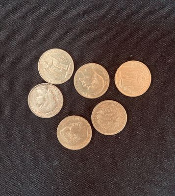 four different types of coins on a black surface