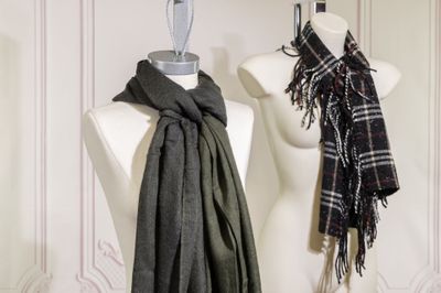 two scarves hanging on a mannequin in a room