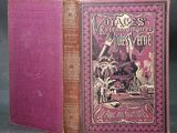 un vieux livre à la couverture rose posé sur une table