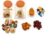 un sac de cailloux et un sac de perles posés sur une surface blanche