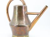 a metal watering can with a metal handle on a white background
