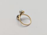 a close up of a gold ring with a pearl on it