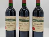 trois bouteilles de vin rouge posées côte à côte sur une table
