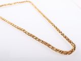 a gold necklace with a braid design on a white background