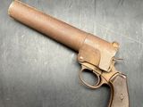 an old gun on a metal surface with a piece of paper