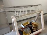 une étagère sur laquelle sont posés des assiettes et des bols, dans une cuisine