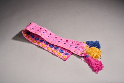 un gros plan sur une cravate rose et bleue ornée de pompons