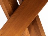 a close up of a wooden table with two crossed legs
