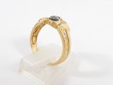 a close up of a gold ring with a black stone