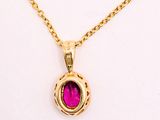 a yellow gold necklace with a pink stone in the center