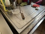 a dirty sink in the kitchen with dirty dishes and utensils