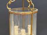 an antique brass and glass lantern hanging from a ceiling