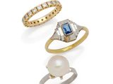three different rings and a pearl ring on a white background