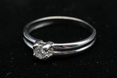 gros plan d'une bague en diamant sur une surface noire