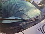 a car that has a surfboard stuck in the windshield of it