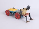 toy figurine of a man with a cart of food on a white background