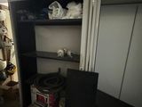 a closet in the basement of a house with a lot of stuff on the shelves
