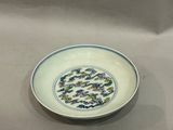 une image représentant une assiette blanche ornée de motifs bleus et verts