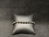 a close up of a pillow with a beaded bracelet on it