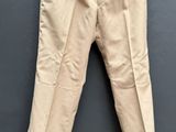 une photo d'un pantalon beige suspendu à une corde à linge