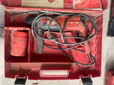 une boîte rouge contenant des outils, posée sur le sol
