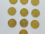 plusieurs pièces d'or sont disposées en cercle sur une surface blanche