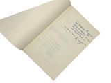 an open book with writing on it on a white surface