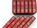 un lot de six livres rouges ornés de motifs dorés