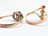 pair of gold rings with diamonds on a white surface