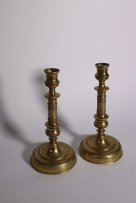 pair of antique brass candlesticks on a white background