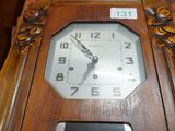 a wooden clock that is on a table with a cell phone